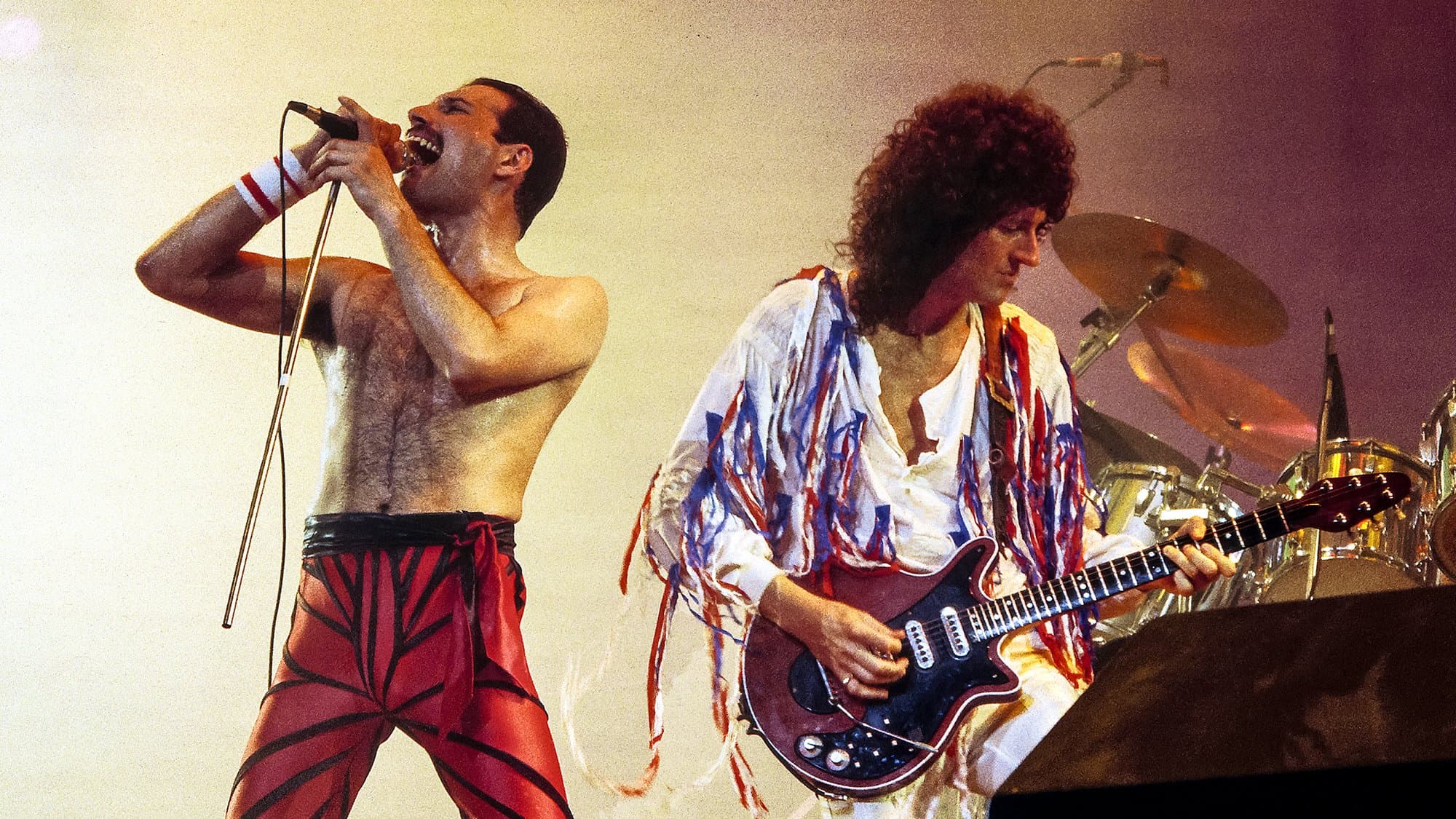 Brian May กับ Red Special ของเขา (ซ้าย) และ Freddie Mercury บนเวที (ขวา)