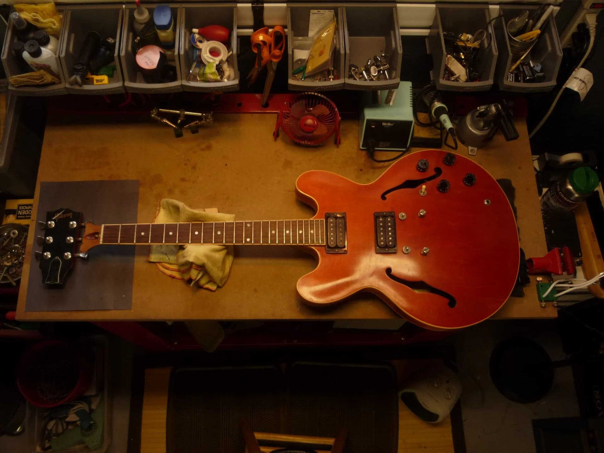 A Gibson ES-333 with its headstock broken off, lying on a repair bench. Photo: Roadside Guitars, CC BY-SA 2.0