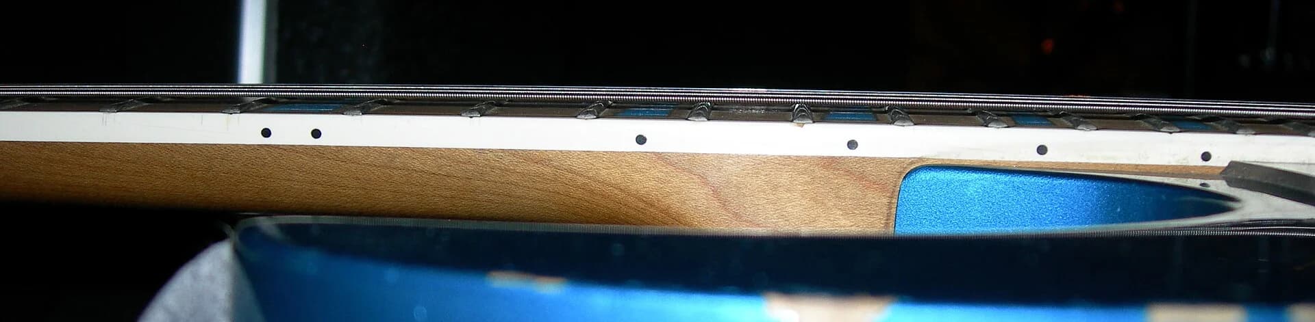 A side view along the neck: the gap between the strings and the frets is the action. Photo: CLI, CC BY-SA 4.0